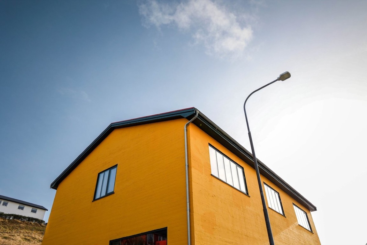 The bright yellow Gula Smiðja building against a blue sky