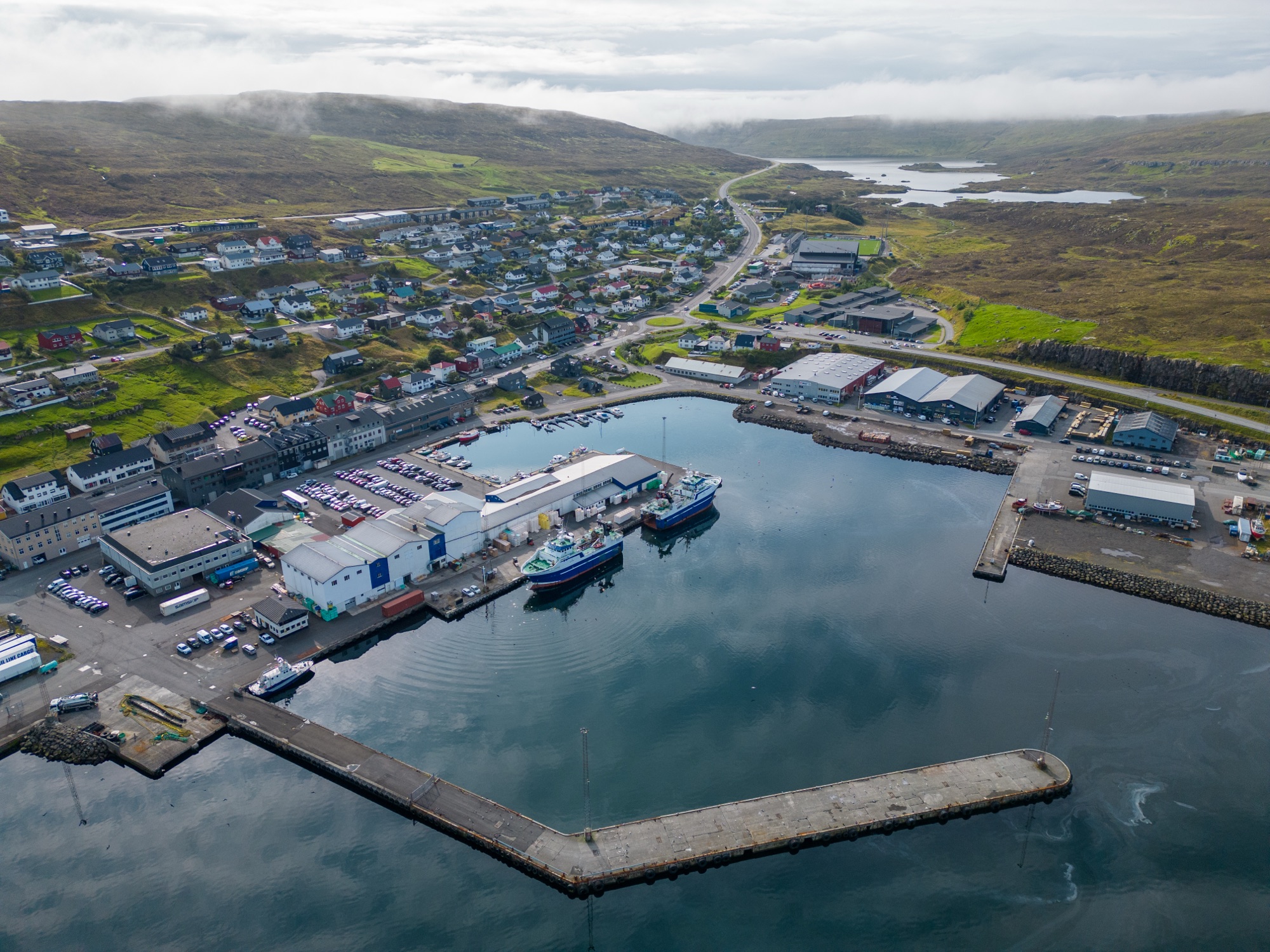 Aerial view of Runavíkar Havn with fishing vessels, quay and breakwater
